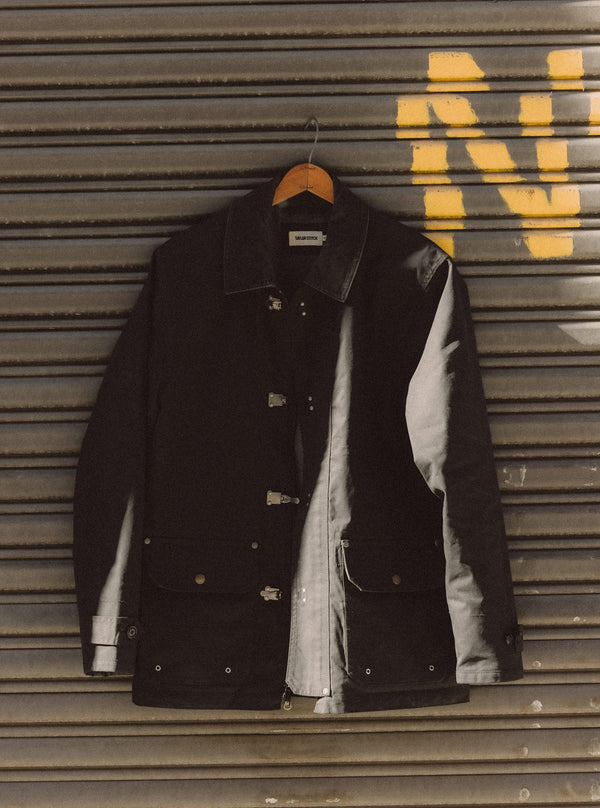 The Cinder Jacket hanging on metal shutters