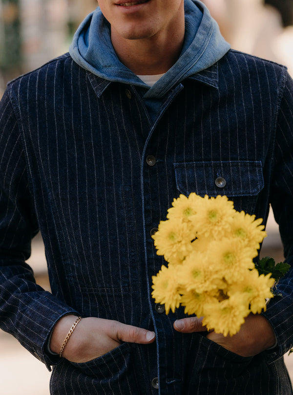 Close up of model holding a bunch of yellow flowers while wearing the Fremont Jacket
