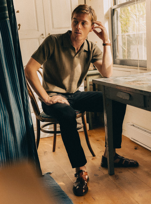 Model sitting by the desk in the Valencia Sweater Polo