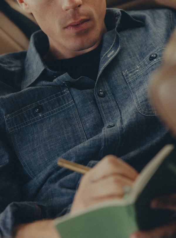 Model wearing the Foundry Shirt, writing in a notebook