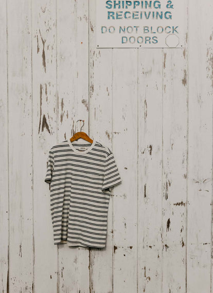 The Organic Cotton Tee in Washed Indigo Stripe hanging on a wall