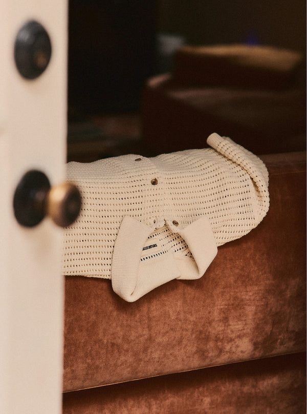 The Monterey Sweater Polo in Vintage White Crochet draped on couch