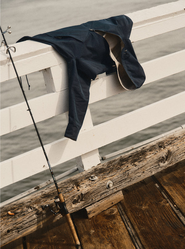 The Squall Anorak hanging on a pier railing