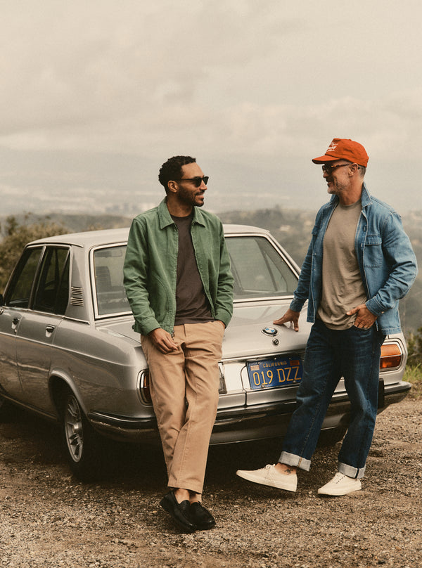 Two models chatting by a vintage car