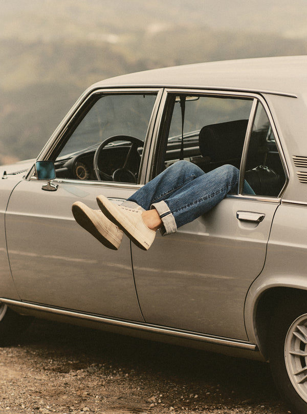 Legs hanging out the window of a vintage BMW