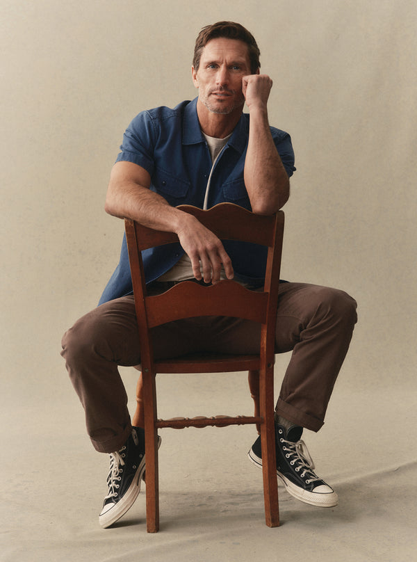Model sitting in The Short Sleeve Mechanic Shirt and Foundation Pant