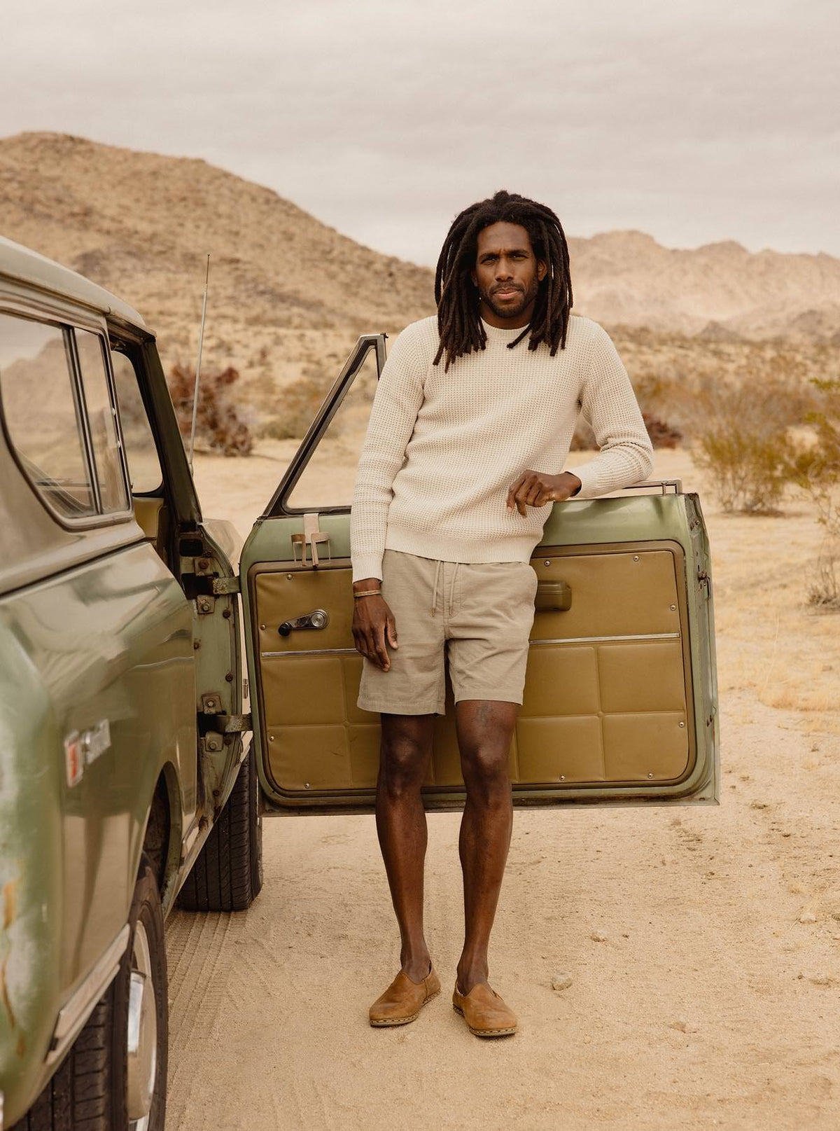 Model beside a vintage car in Joshua Tree.