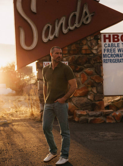 Model wearing The Button Down Polo in Cilantro Herringbone with washed jeans