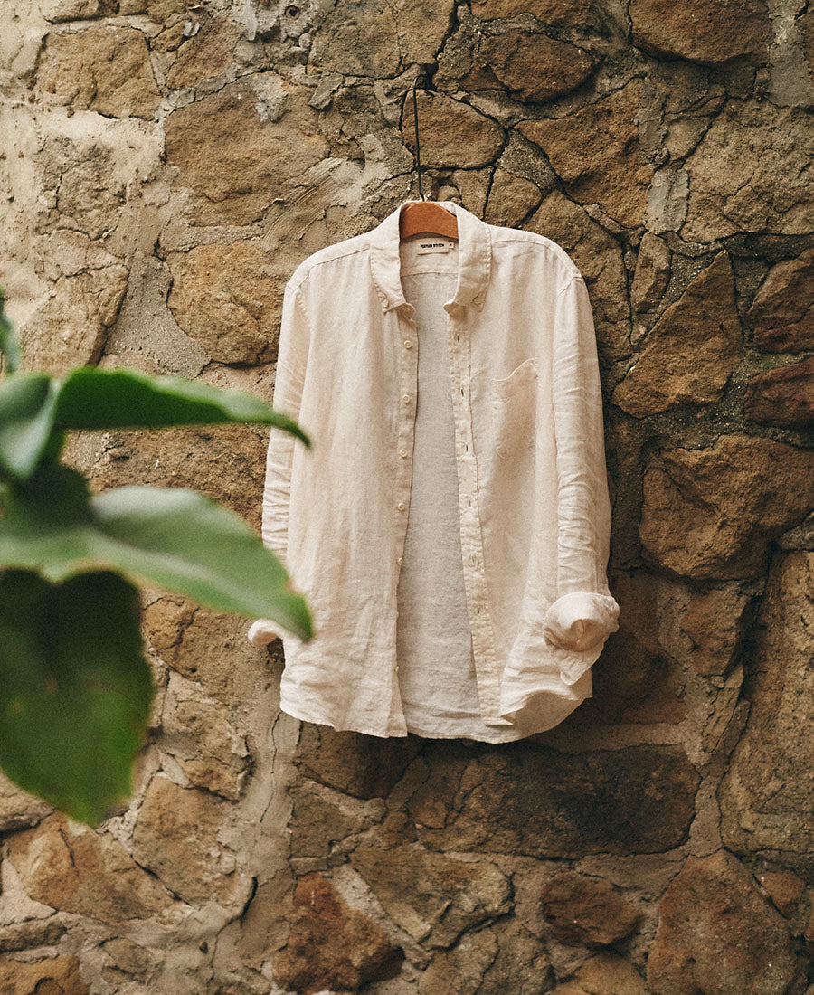 The Jack in Vintage White Linen hanging on a rockface, by Taylor Stitch