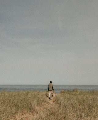 fit model walking on the beach for The Wellfleet Edit, by Taylor Stitch
