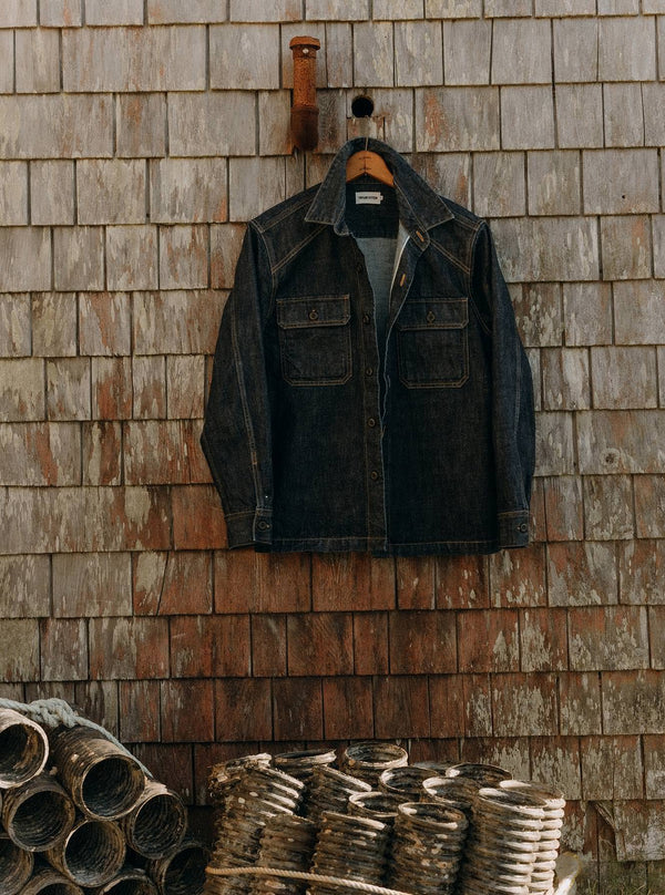 The Shop Shirt in Rinsed Indigo Selvedge hanging on the exterior of a cabin