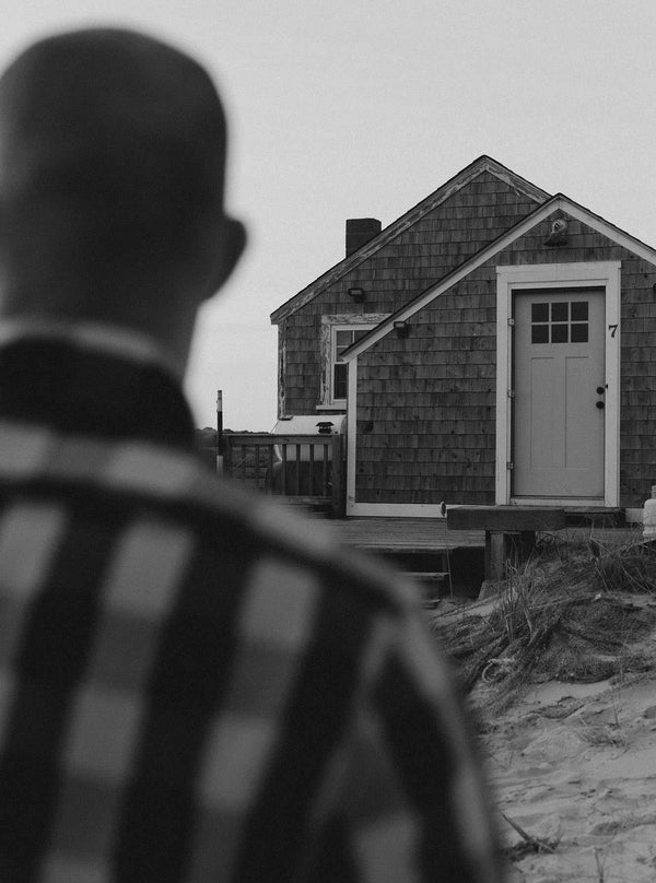 Model facing a wooden cabin in Wellfleet