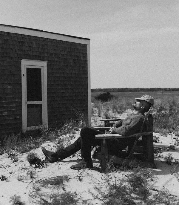 Model reclining on a chair outside a cabin in Wellfleet