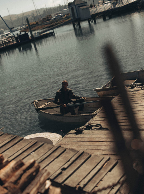 Model in a row boat by the dock