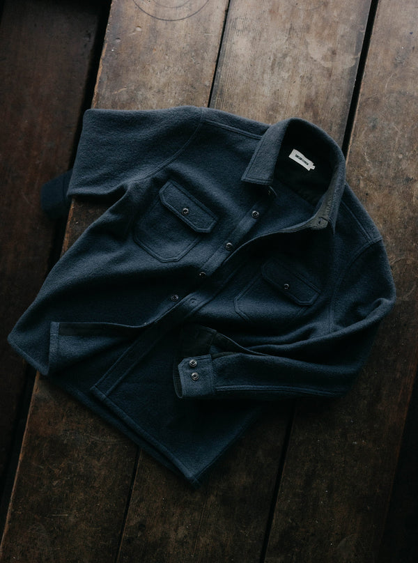 The Connor Overshirt in Dark Navy, laid out on a wooden floor