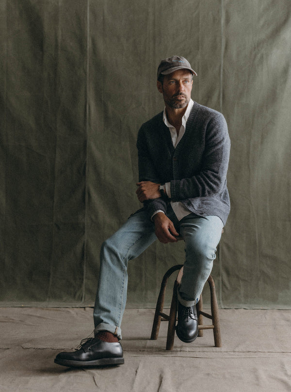 Model wearing The Eastmoor Cardigan, sitting on a stool