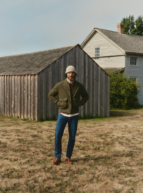 model wearing the Corp Jacket, standing by a barn in Maine