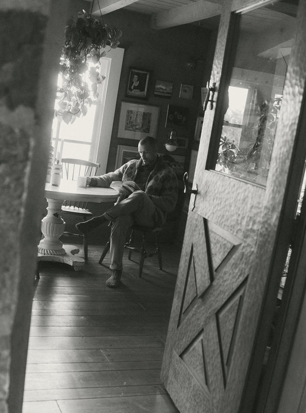 Model sitting in a living room, reading a book