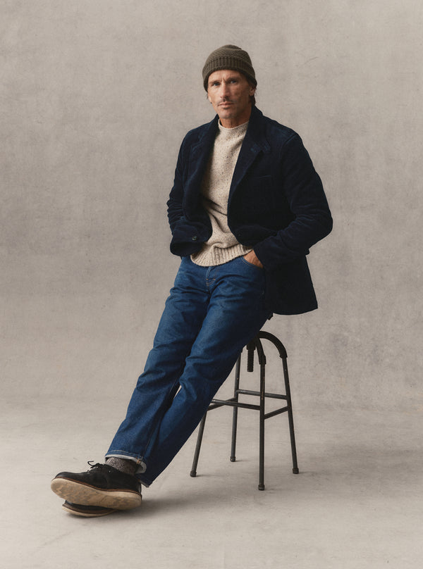 Model sitting on a stool, wearing The Riley Sportcoat