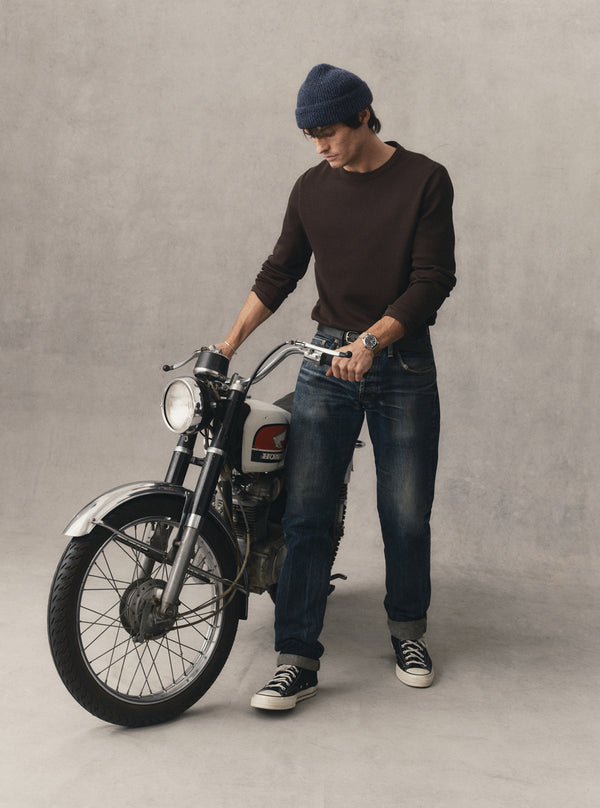 Model standing by a vintage motorbike