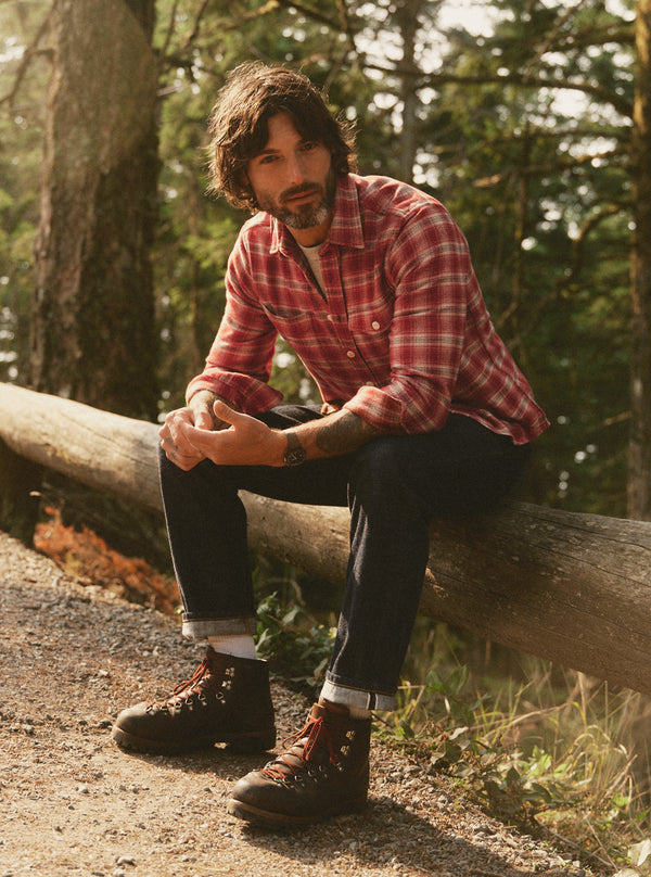 Model sitting on a log in the Crater Shirt