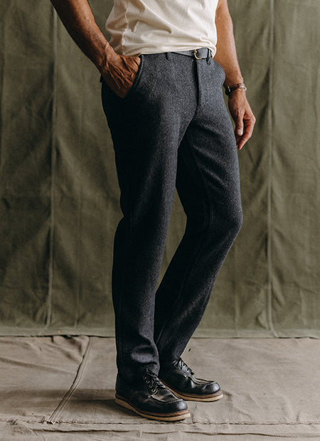 fit model posing in The Carnegie Pant in Heather Charcoal Herringbone, by Taylor Stitch