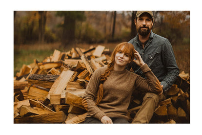 Kate & Josh near posing next to chopped lumber