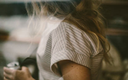 Blurred close-up of a woman drinking from a can.