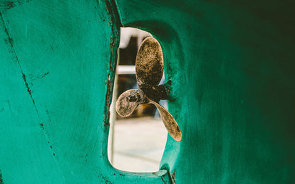 Close up of the propellor on a blue-keeled yacht.