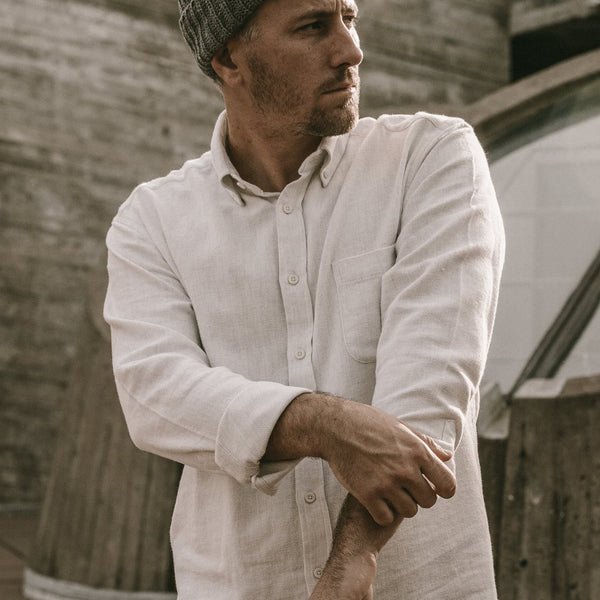 Our guy rolling up the sleeve on his white button-down.