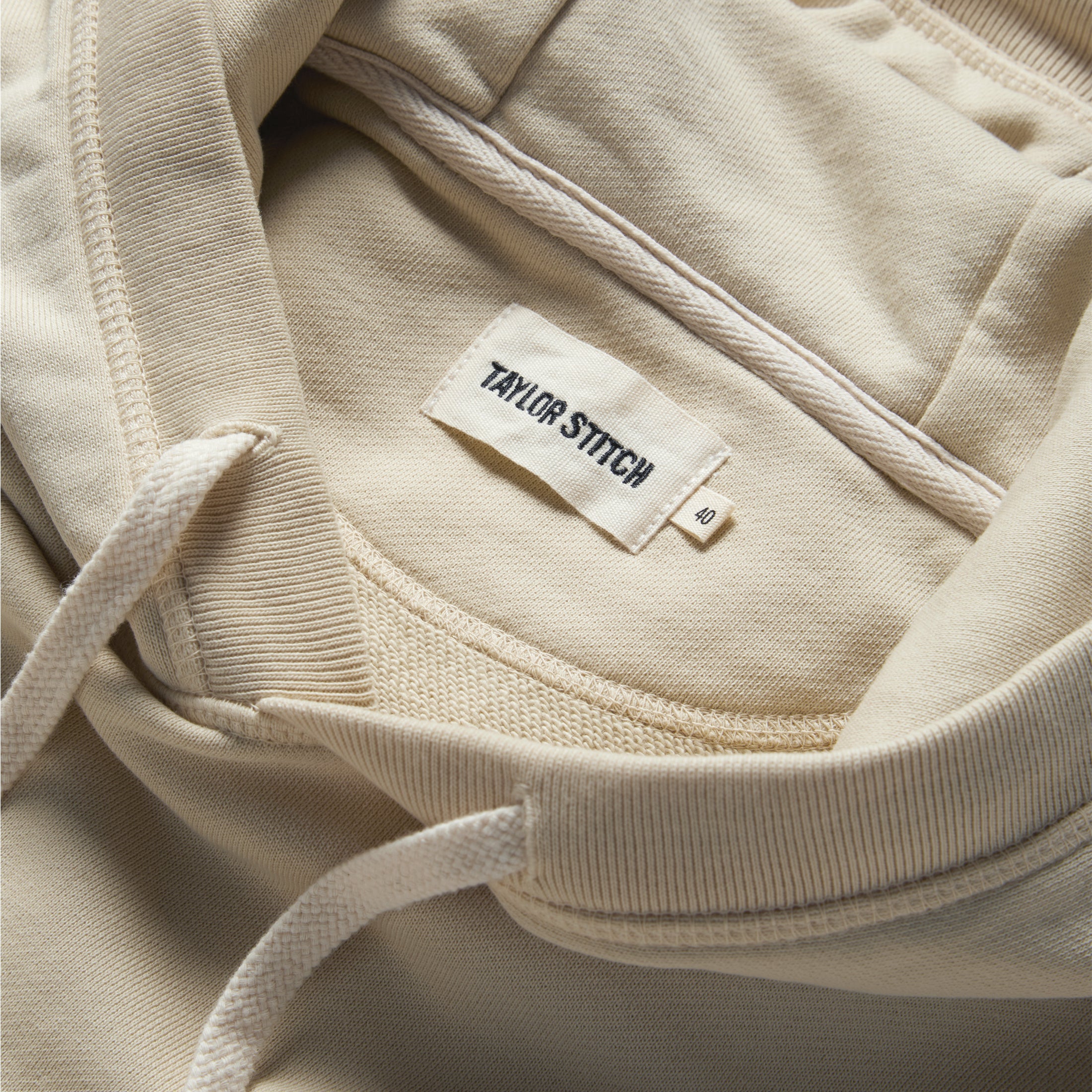 material shot of the label and drawstring on The Fillmore Hoodie in Natural, Knits by Taylor Stitch