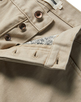 material shot of the buttons and map pocket printing on The Camp Pant in Sand Boss Duck, Bottoms by Taylor Stitch