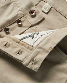material shot of the buttons and map pocket printing on The Chore Pant in Sand Boss Duck, Bottoms by Taylor Stitch