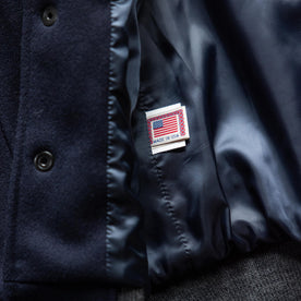 material shot of the made in USA label on The Golden Bear Snap Bomber in Midnight Wool
