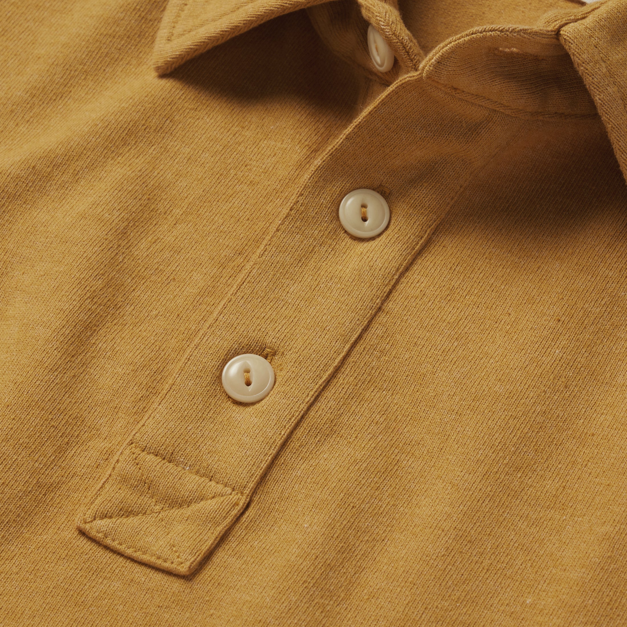 material shot of the buttons on The Heavy Bag Polo in Gold, Knits by Taylor Stitch