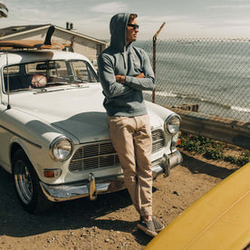 fit model leaning against a vintage car in The Apres Pant in Khaki Double Cloth