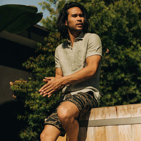 fit model sitting outdoors in The Short Sleeve California in Army Hemp