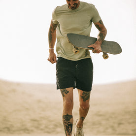 fit model holding a skateboard and running in The Après Short in Dark Navy Pinwale