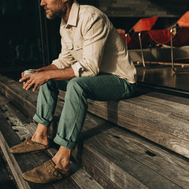 fit model sitting on wooden steps in The Chore Pant in Ocean Boss Duck