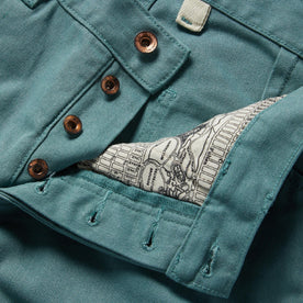material shot of the buttons and map pocket printing on The Chore Pant in Ocean Boss Duck