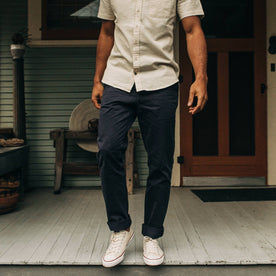 fit model wearing The Democratic Foundation Pant in Organic Dark Navy while walking on porch