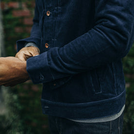 fit model adjusting the cuffs on The Dispatch Jacket in Indigo Cord