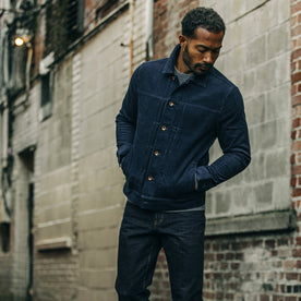 fit model posing in an alley in The Dispatch Jacket in Indigo Cord