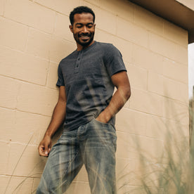 fit model wearing The Short Sleeve Heavy Bag Henley in Dark Navy with a hand in his jean pocket