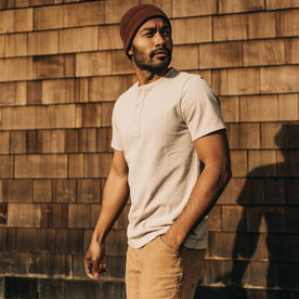 fit model wearing The Short Sleeve Heavy Bag Henley in Sand with his hand in his pocket