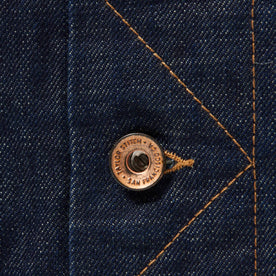 material shot of button on stitched placket of The Long Haul Jacket in Rinsed Organic Selvage