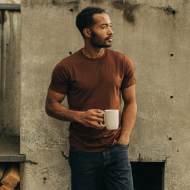 fit model holding a coffee cup and wearing The Merino Tee in Russet