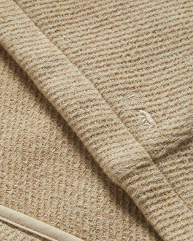 material shot of the Taylor Stitch logo on The Nomad Hoodie in Flax Twill