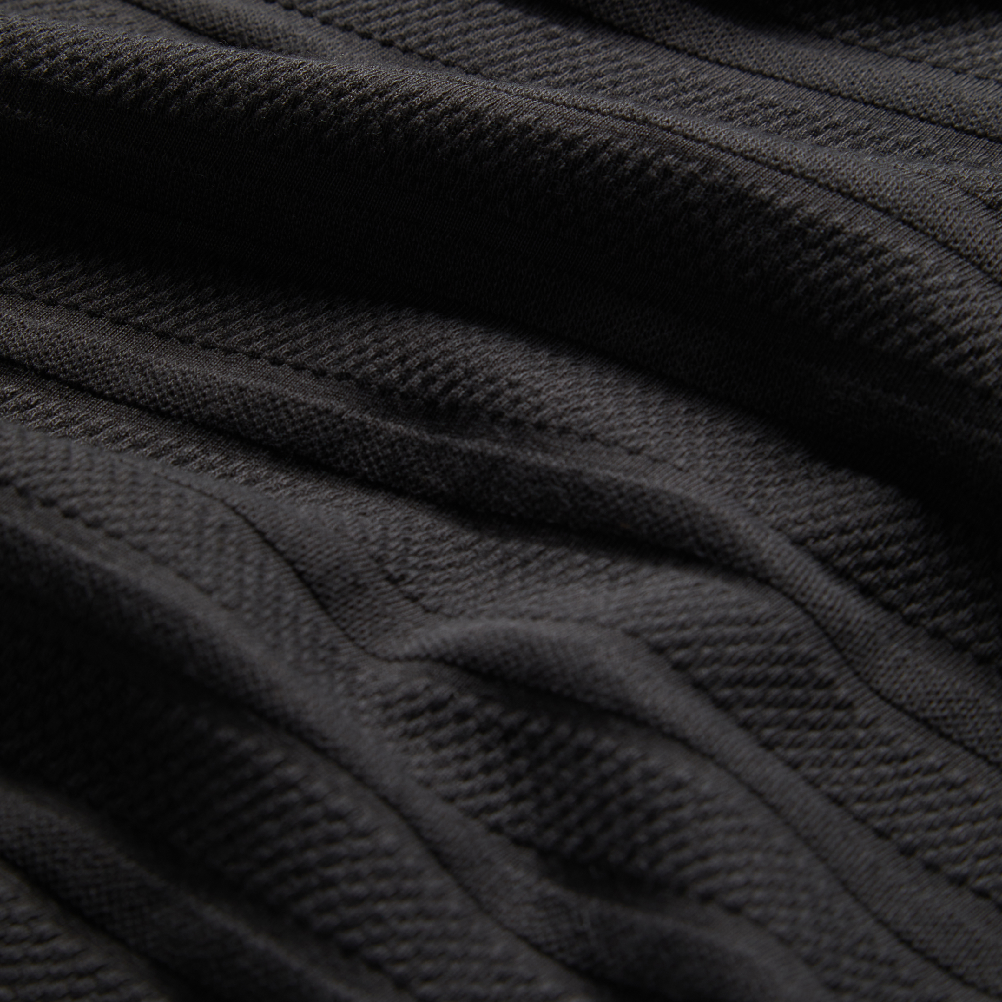material shot of texted fabric of The Polo in Dark Charcoal Jacquard, Knits by Taylor Stitch