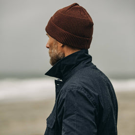 fit model with popped collar looking out over coast in The Rib Beanie in Russet